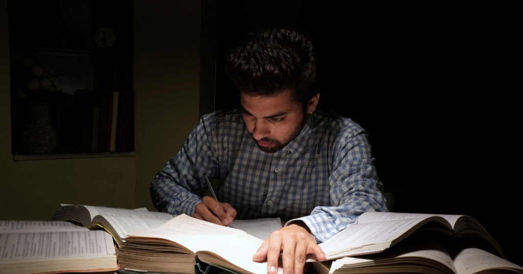 studying man with lots of books on the table