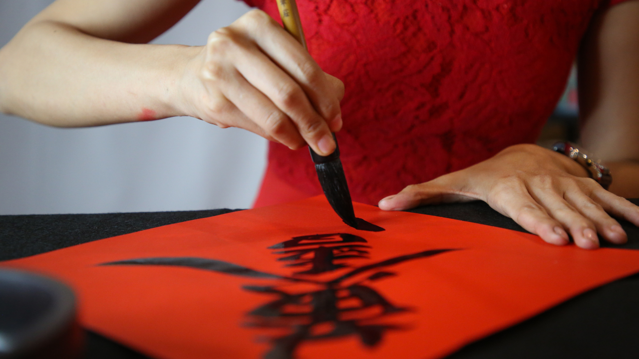 Female writing Chinese calligraphy